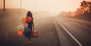 Partire – una ragazza con valigia e palloncini – Foto di Pexels/Pixabay
