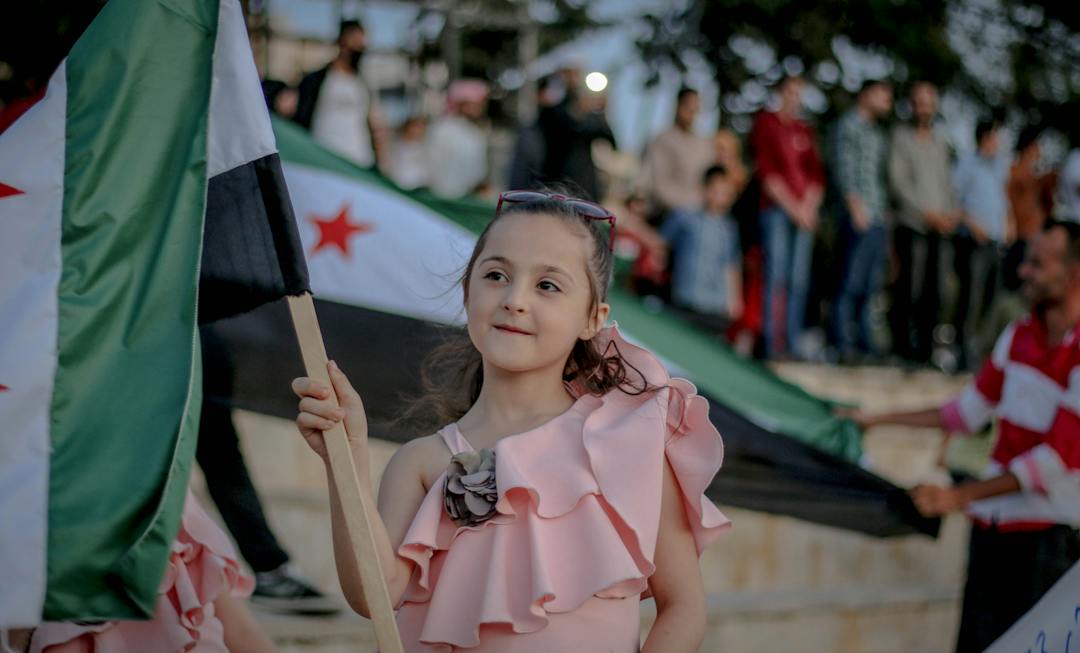 Siria, slow travel, viaggiare con lentezza, bambina siriana, bandiera