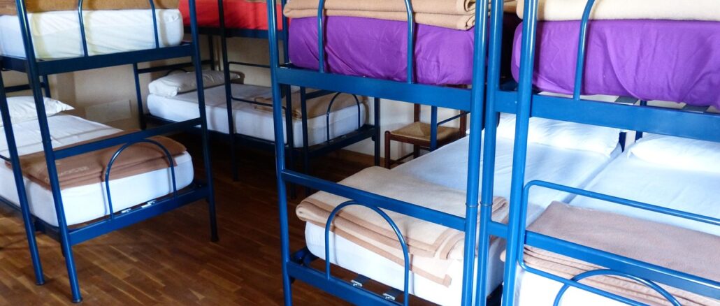 Dormitorio di ostello con letti a castello e coperte