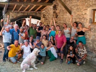 Volontariato e scambio di ospitalità in Francia in una fattoria dell’Ardèche, con gruppo di partecipanti davanti a un edificio rurale in pietra