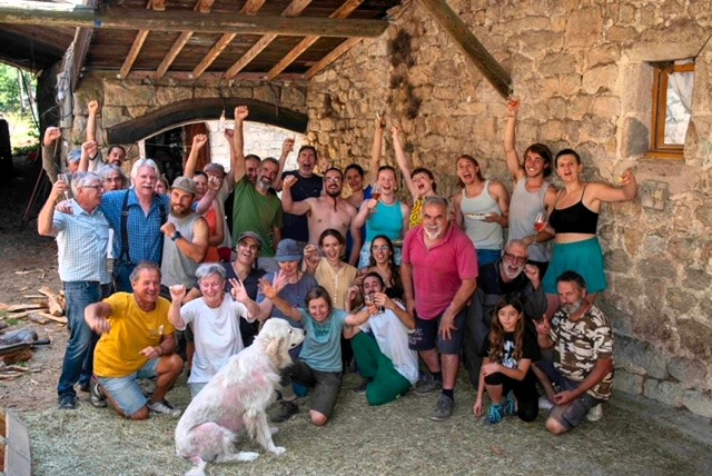 Volontariato e scambio di ospitalità in Francia in una fattoria dell’Ardèche, con gruppo di partecipanti davanti a un edificio rurale in pietra
